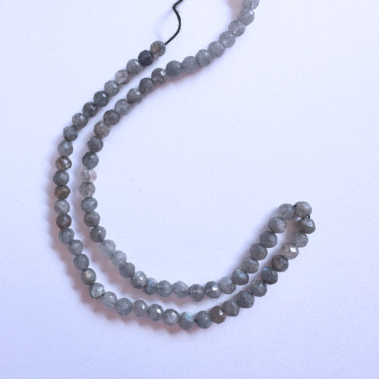 Stone beads with faceted Labradorite arranged in a neat strand, ideal for handmade jewellery components.