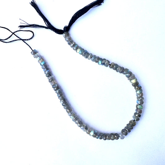 Labradorite faceted rondelle beads with grey-blue tones and iridescent shimmer.