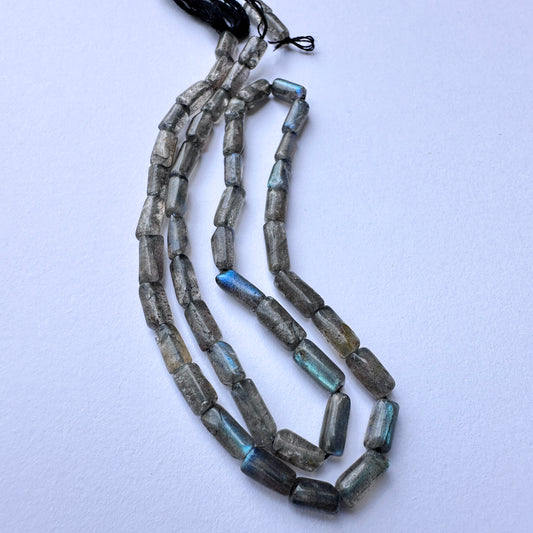 Close-up of natural gemstone beads in labradorite with glossy surface and consistent sizing across 40 carats.