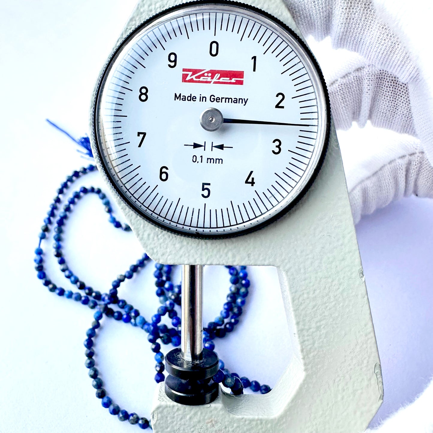 A dial gauge measures the Lapis Lazuli faceted rondelle 3.5mm gemstone.