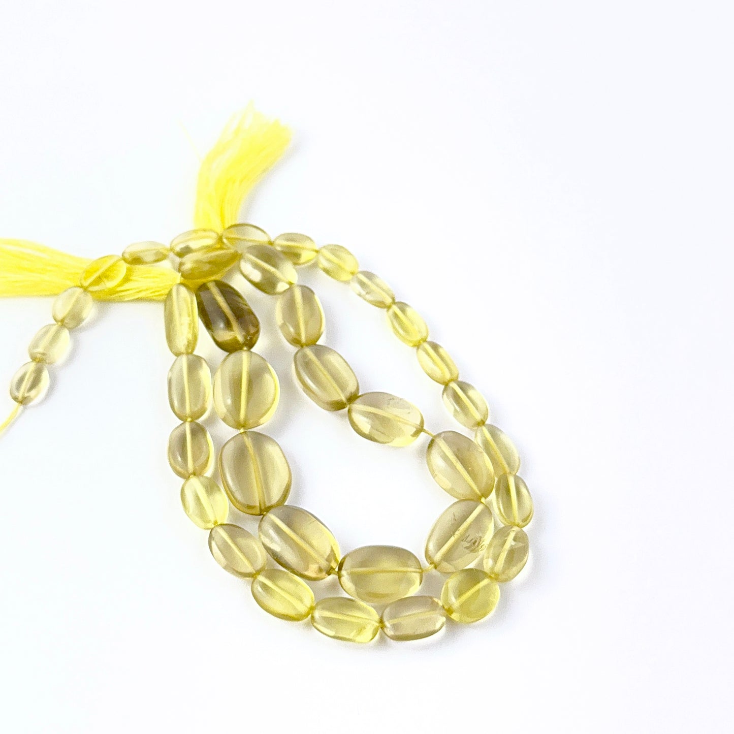 Lemon Quartz smooth oval beads in a long strand, displaying mixed sizes and refined craftsmanship