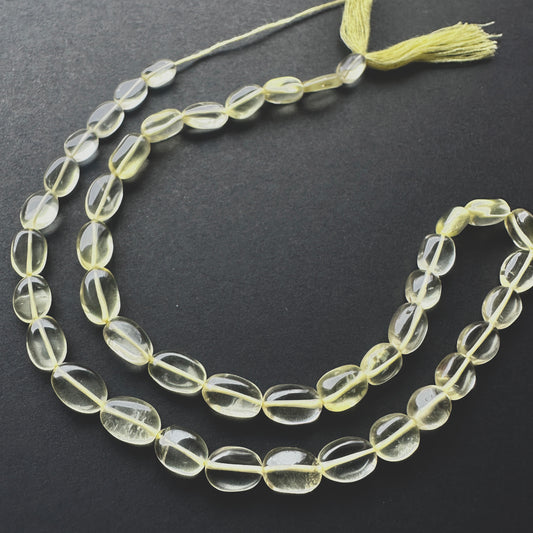 Stone beads with smooth Lemon Quartz arranged in a neat strand, ideal for handmade jewellery components.