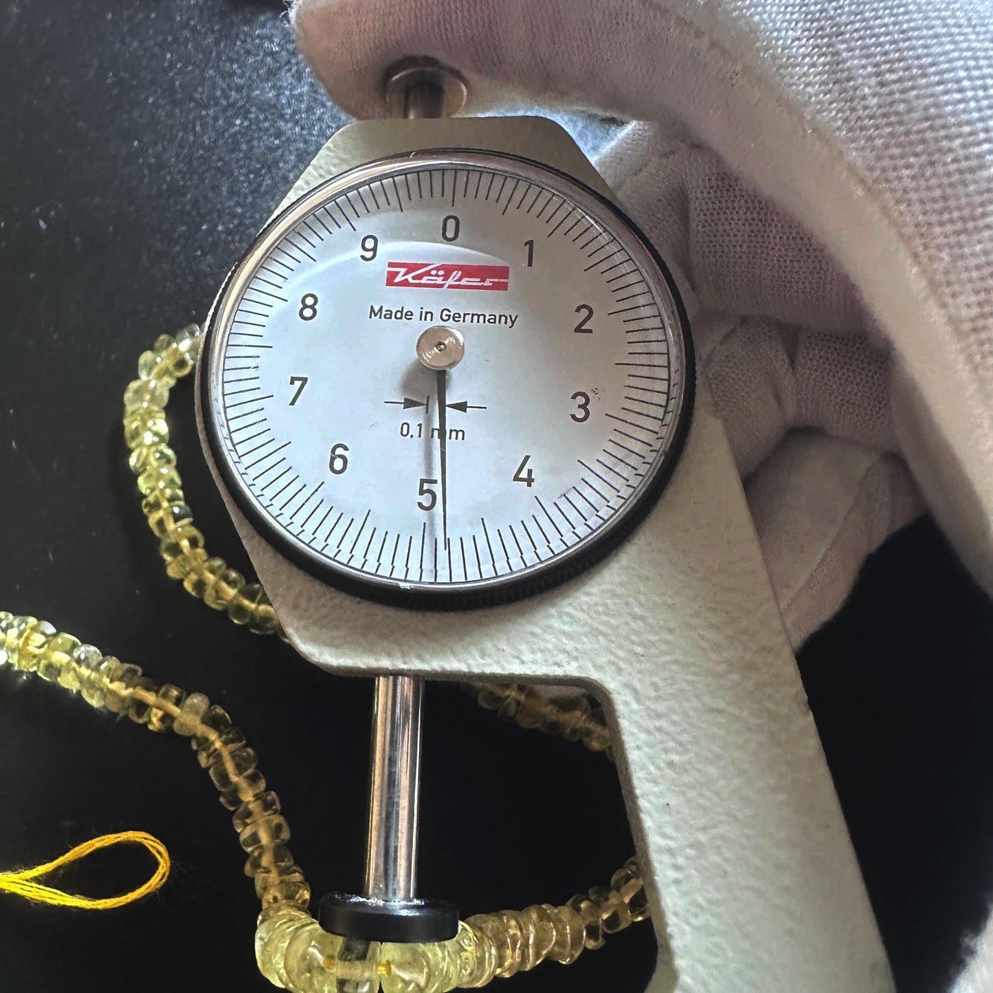 A dial gauge measures the Lemon Quartz smooth wheel 4.5mm gemstone.