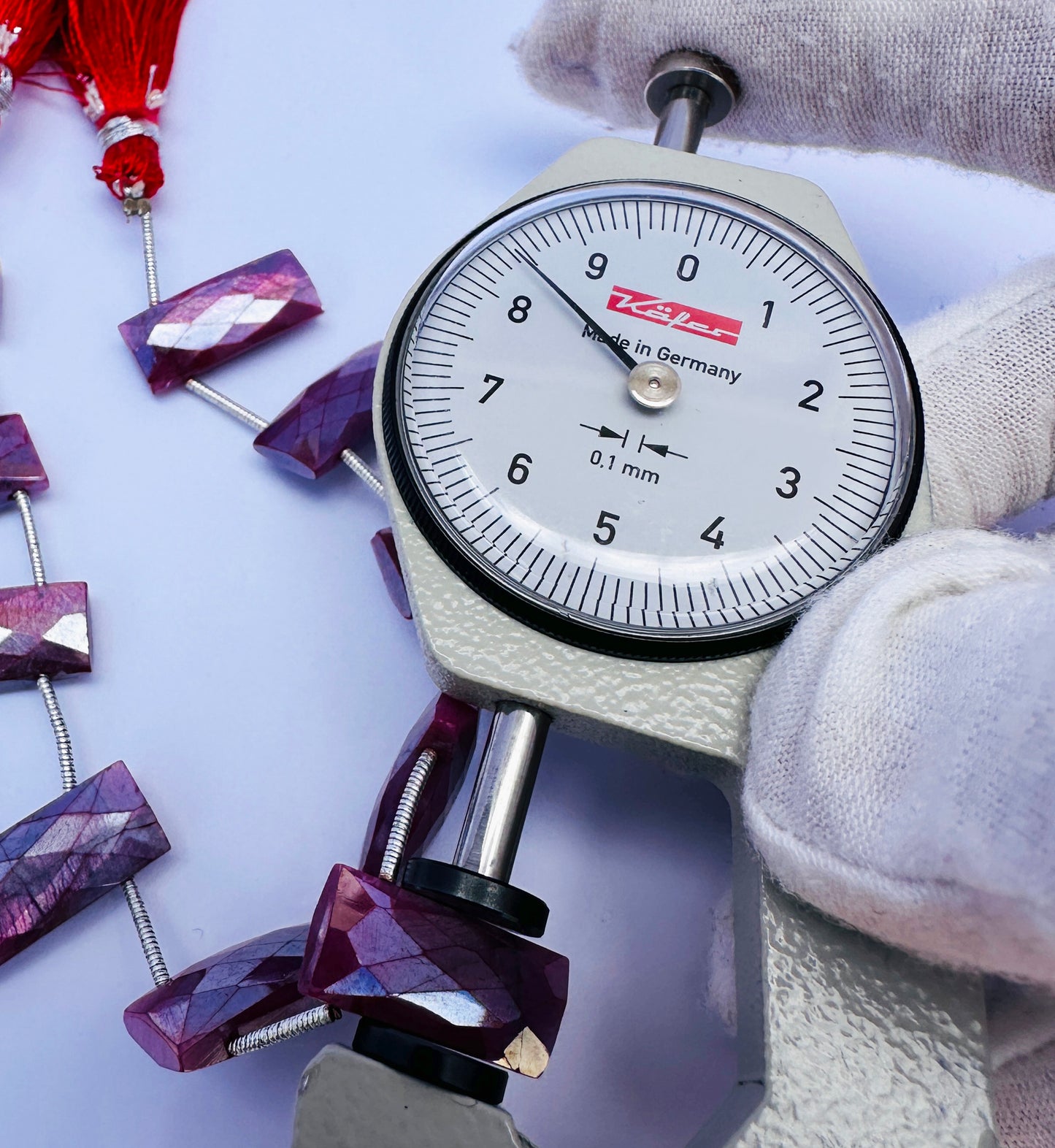 A dial gauge measures the Moonstone Coated faceted rectangle 19×8mm to 19X8.5mm gemstone.