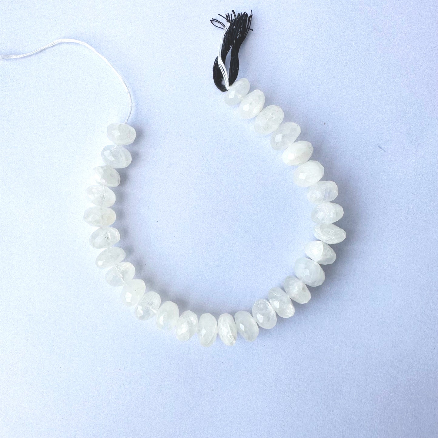 Moonstone beads arranged in a strand with consistent cut and luminous colour.
