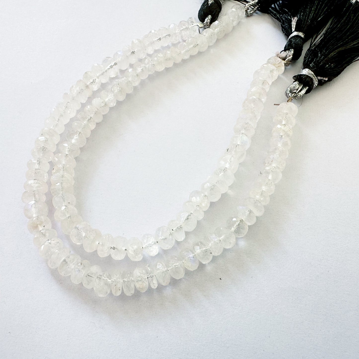 Neatly arranged 6.3–6.5mm Moonstone faceted rondelle beads reflecting pale shimmer.