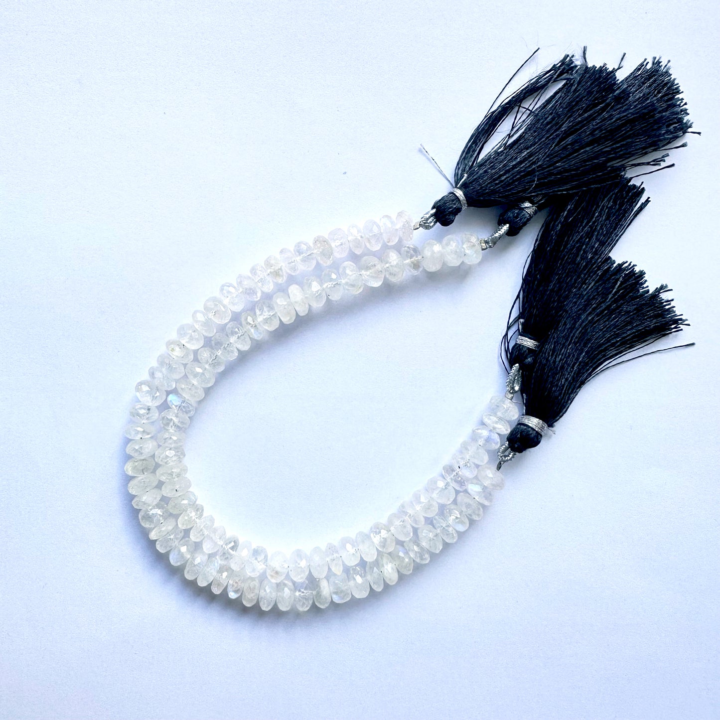 Moonstone beads with faceted rondelle cut reflecting soft blue and cream tones.