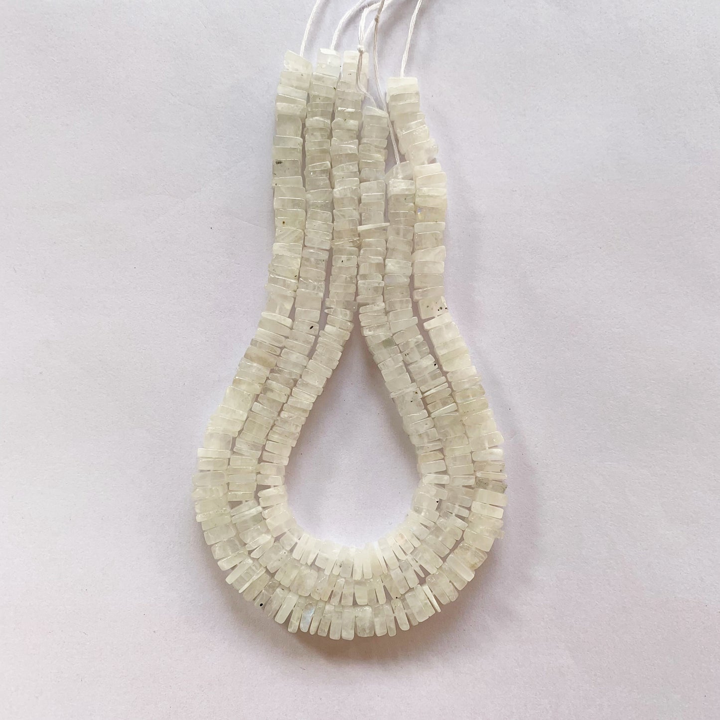 Close-up of smooth Moonstone square beads showing 5–5.5mm and 6–6.5mm sizes.