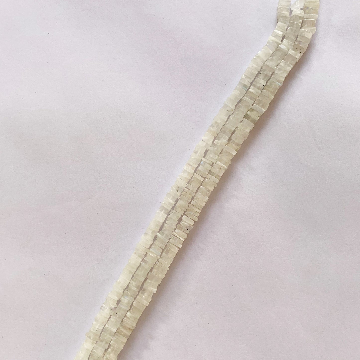 Moonstone beads with a flat heishi cut, arranged in a clean, uniform strand.