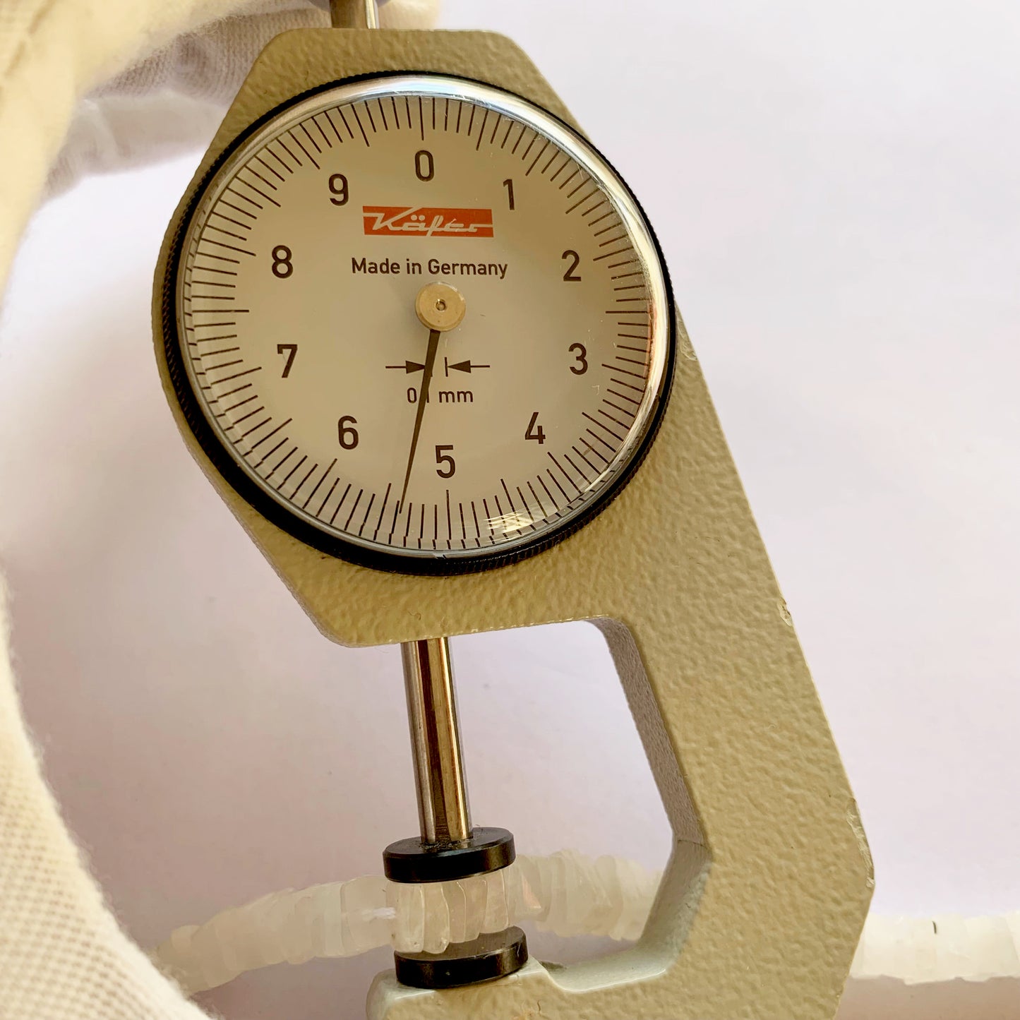A dial gauge measures the Moonstone heishi square 5–5.5mm gemstone.