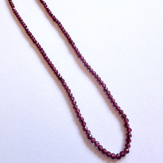 Close-up of Mozambique Garnet stone beads showing precision faceting and rich colour.