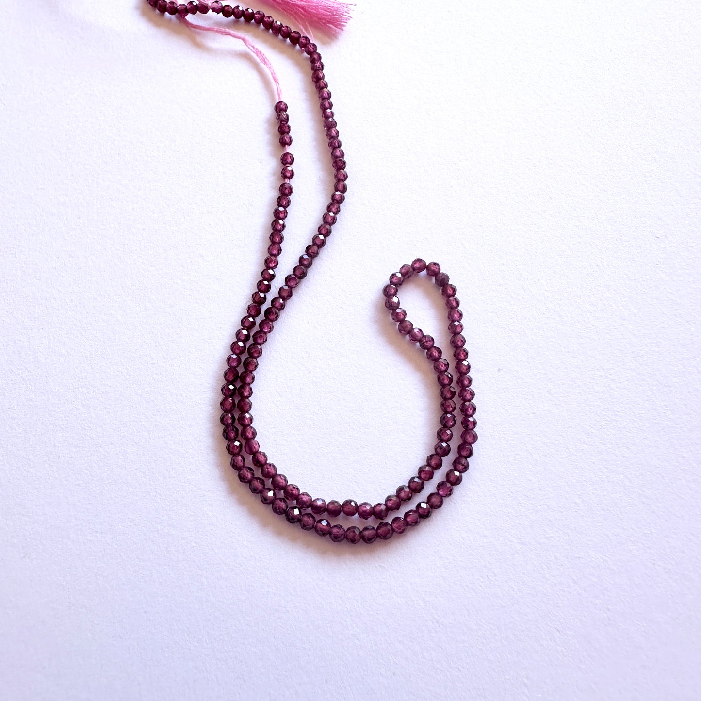 30cm strand of Mozambique Garnet gemstone rondelles arranged for DIY jewellery inspiration.