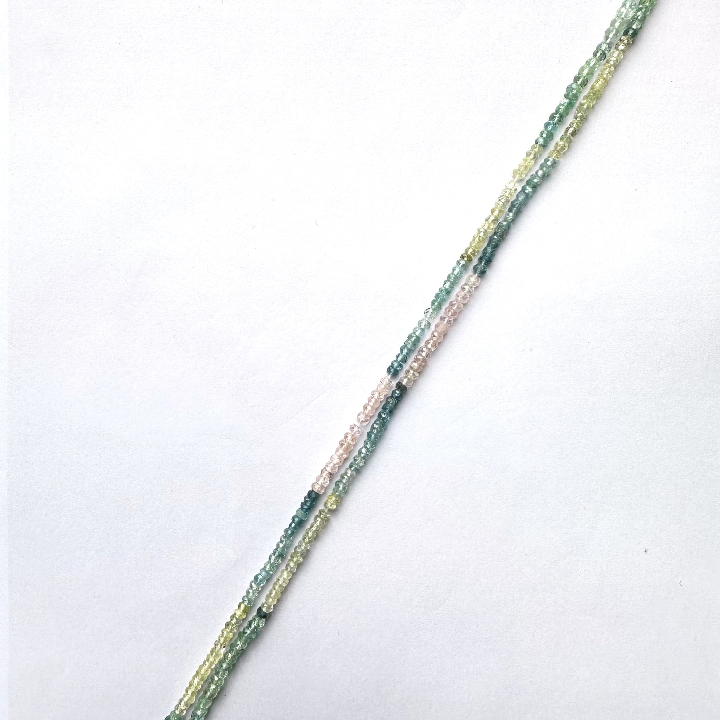Faceted Multi Aquamarine rondelle beads with blue gradient tones arranged on a 32cm strand.