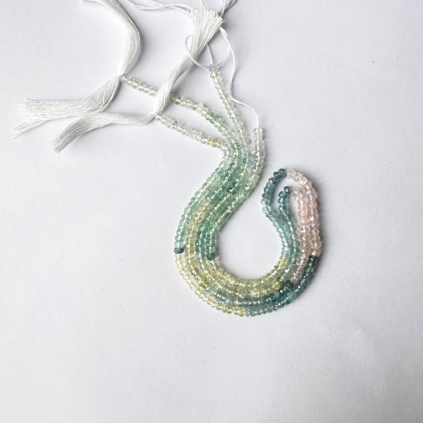 Light-catching Multi Aquamarine rondelles displayed on a natural stone surface