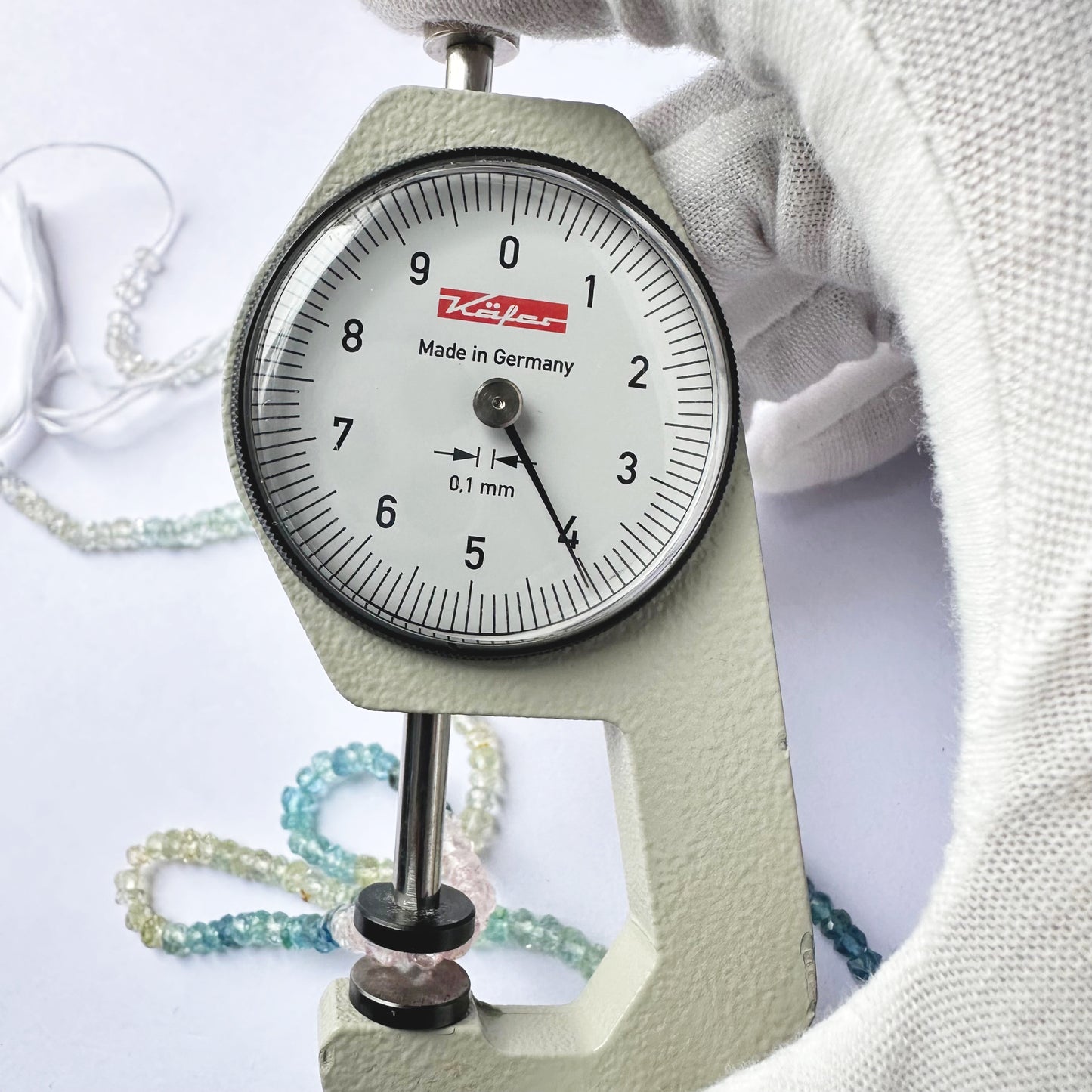 A dial gauge measures the Multi Aquamarine Faceted Rondelle 3.5–4mm gemstone.