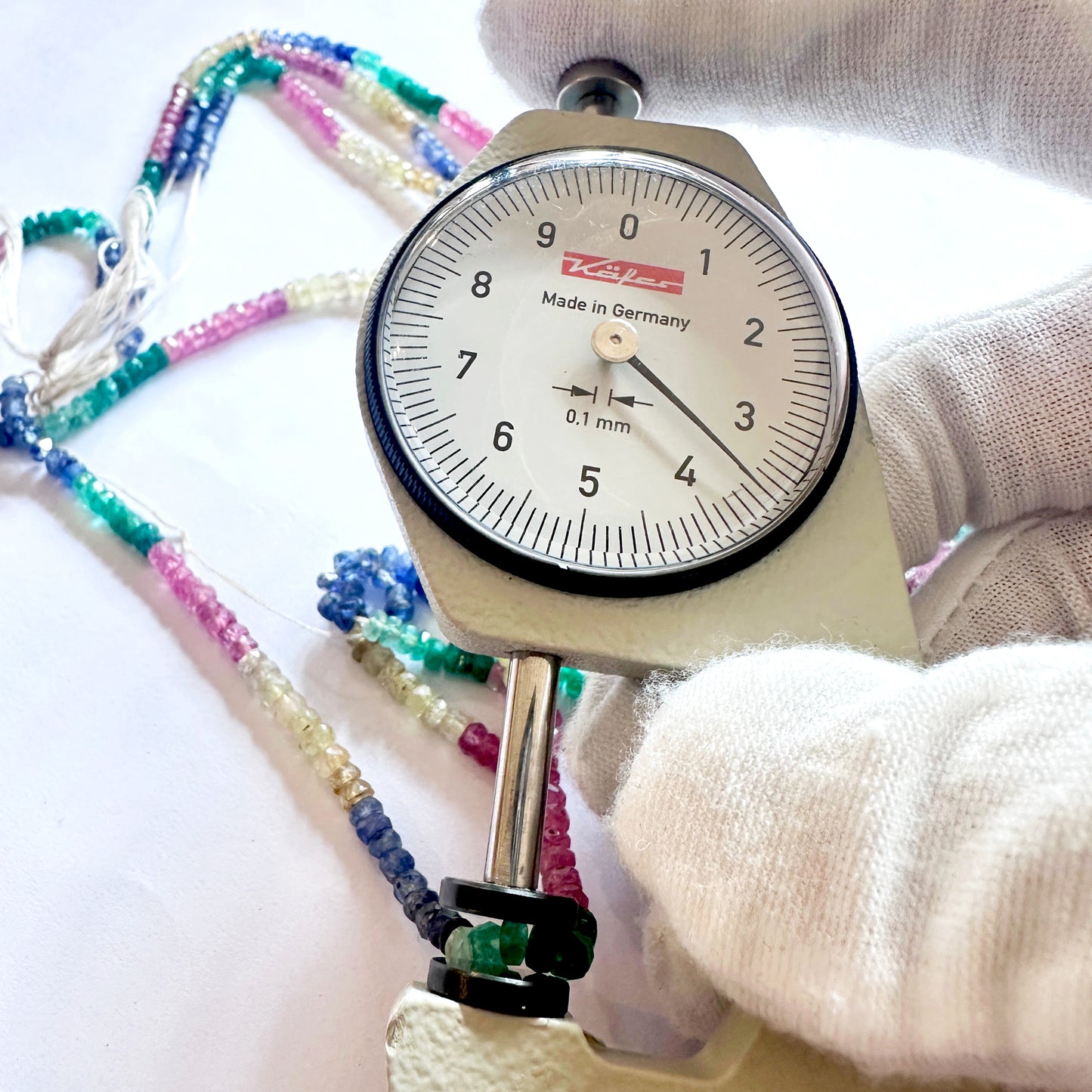 A dial gauge measures the ruby rondelle 3.4-3.8mm gemstone.