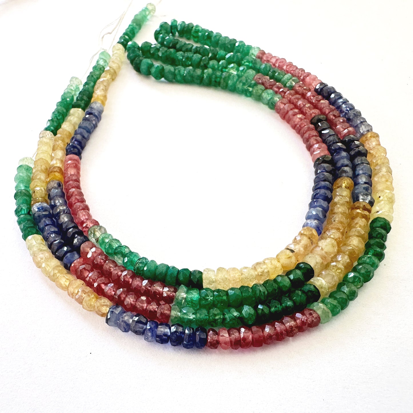 Colourful rondelle gemstones with faceted cuts sparkle under light, displaying premium polish and clarity.