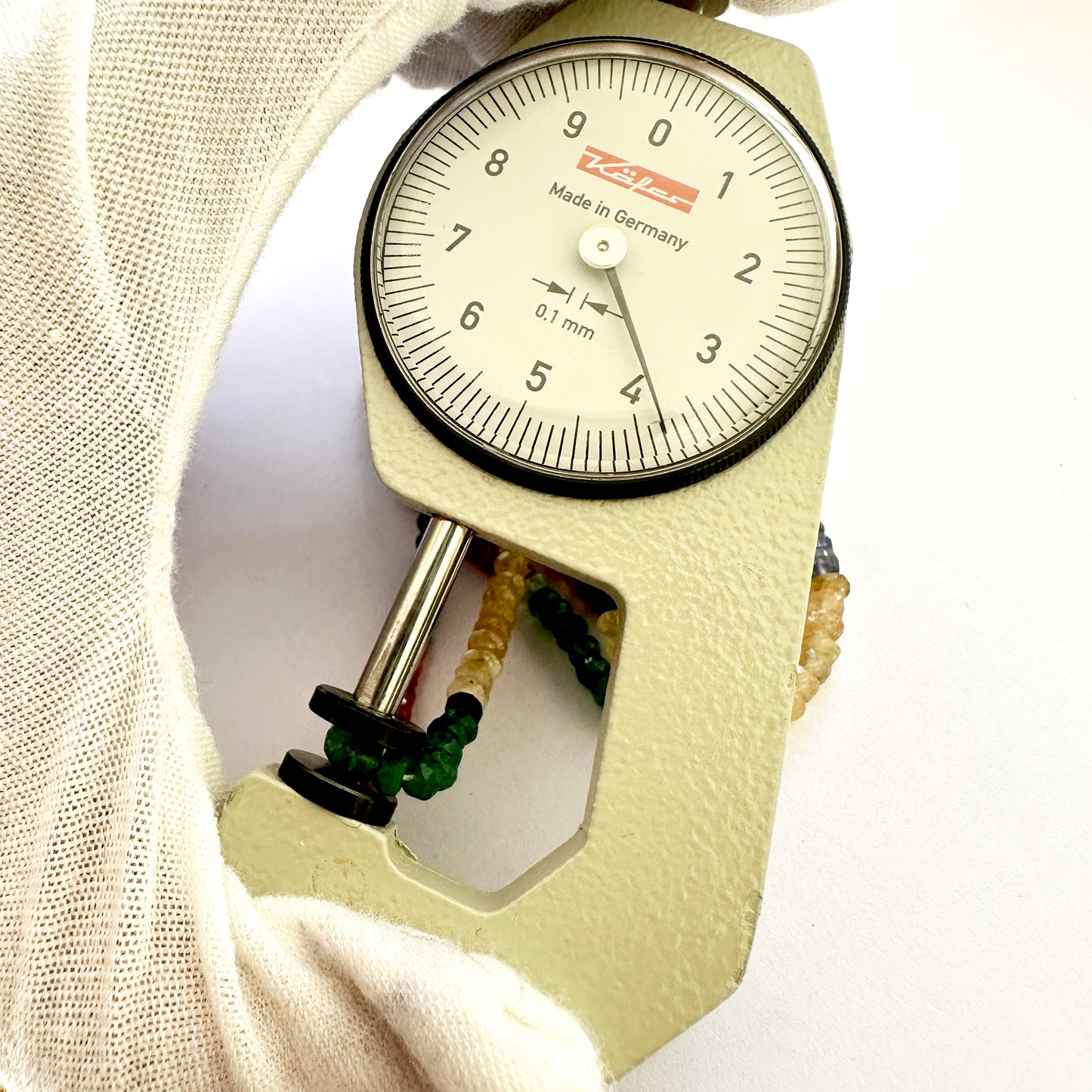 A dial gauge measures the Multi Precious faceted rondelle 3.5mm -4mm gemstone