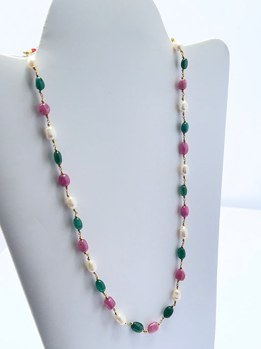 Close‑up of 7–7.5mm tumble ruby, emerald and pearl beads arranged on a finished necklace.