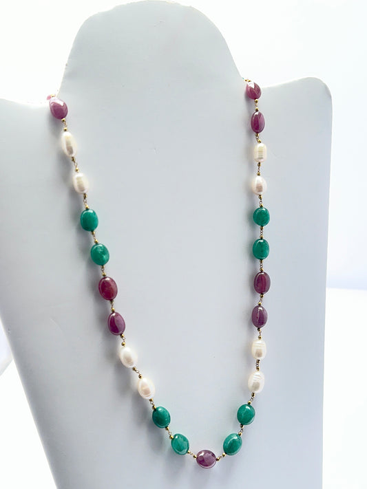 Ruby, emerald and pearl necklace with smooth and textured beads showing rich colour contrast.