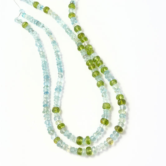 Close view of Peridot and Aquamarine faceted rondelles arranged on a 29cm strand for handmade jewellery components.
