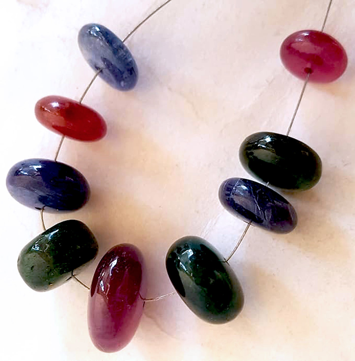 Premium 82 carat gemstone beads in rondelle cut display deep reds, blues, and greens with elegant clarity.