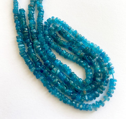 Close-up of neon apatite gemstone beads showing their polished wheel cut and vibrant colour.