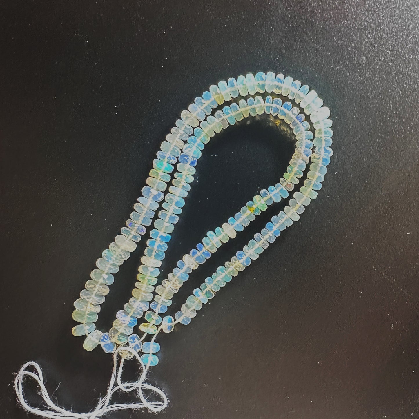 Close-up of 5.5-7.0mm Opal beads showing faceted surfaces and vibrant hues.