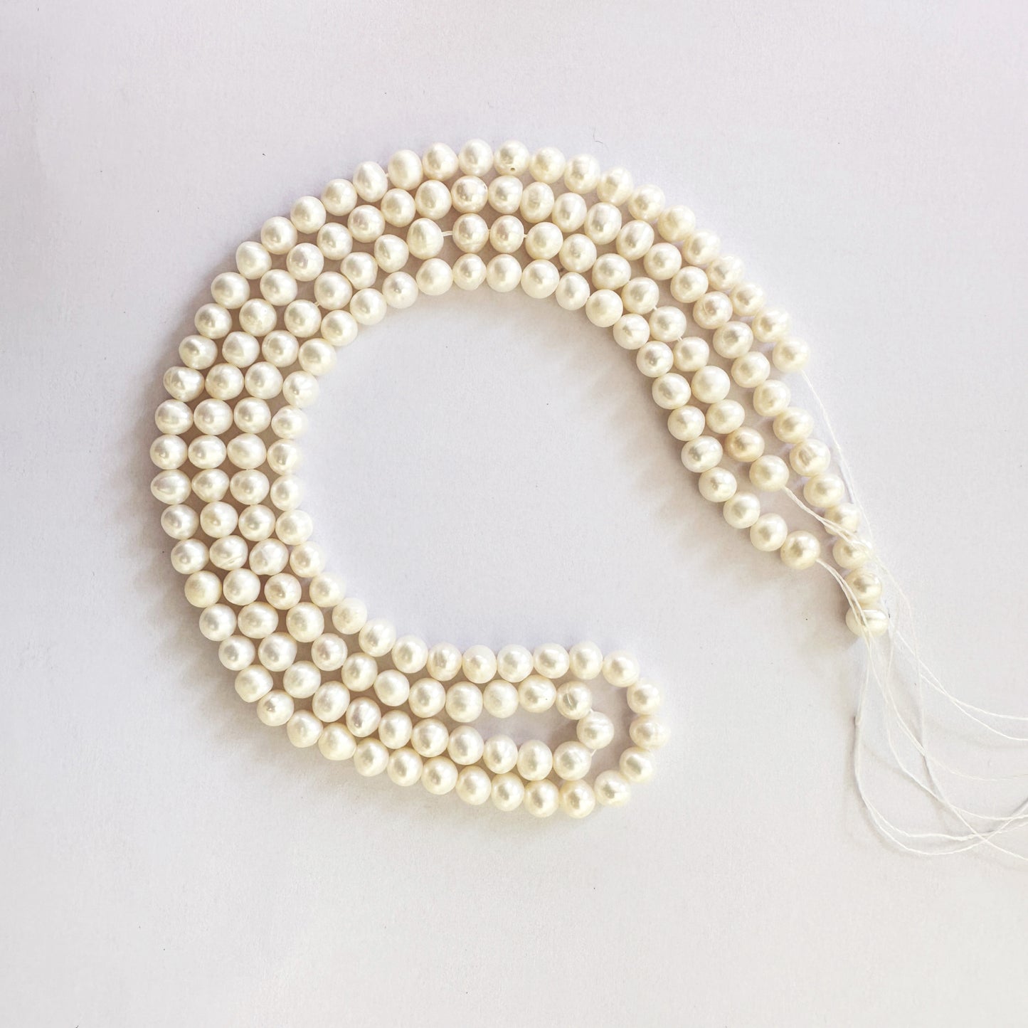 Elegant natural pearls in uniform round shape shimmer with soft pearlescence.