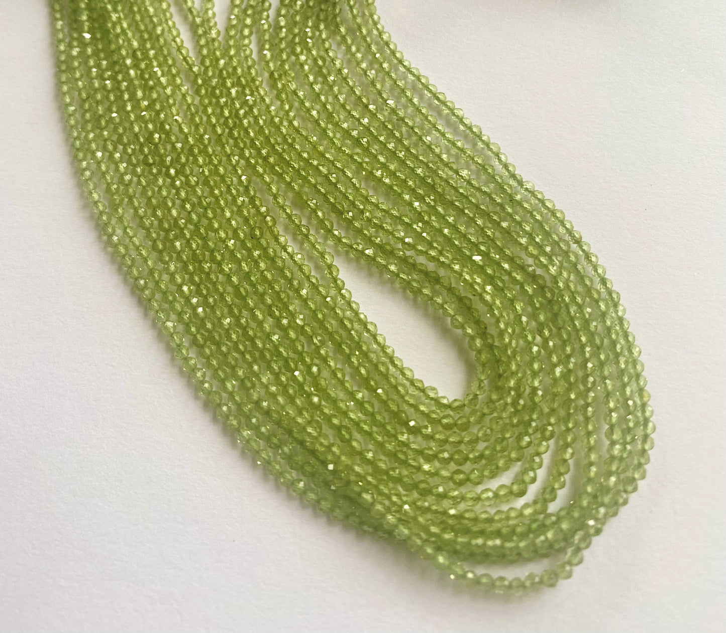Natural Peridot beads in tiny faceted rondelles, shimmering across a fine 32cm length.