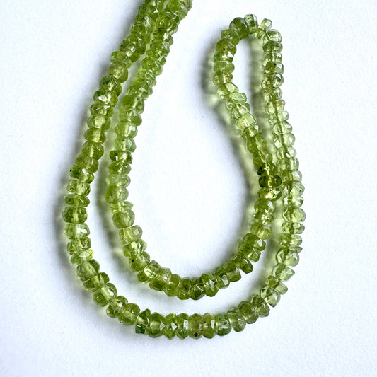 Stone beads with faceted Peridot arranged neatly, ideal for handmade jewellery components.