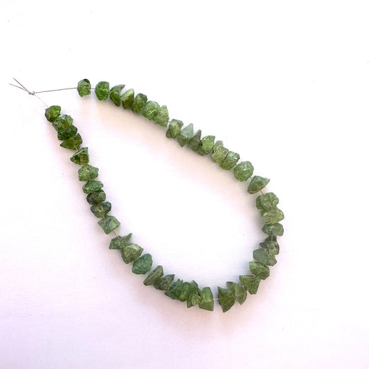 Peridot rough beads with natural green tones and centre-drilled 7.5-9mm size.