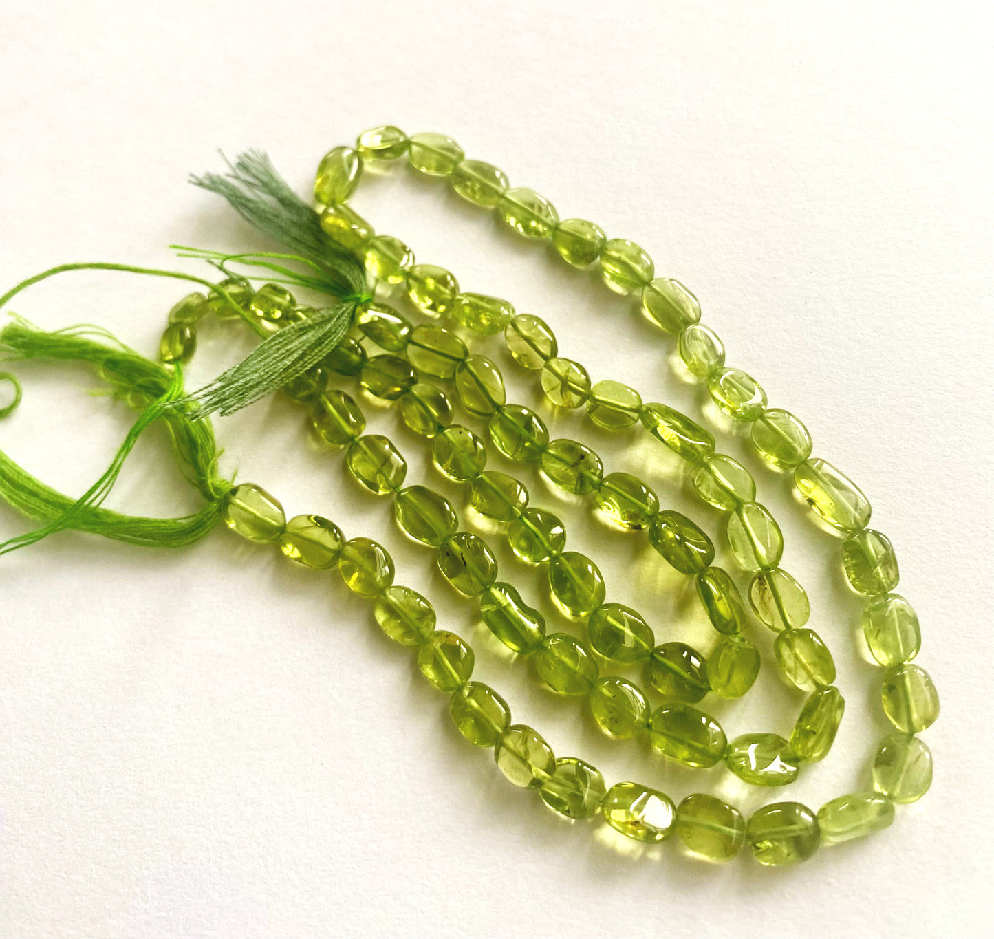 Peridot oval beads with 0.5mm holes, perfect for jewellery making and gemstone crafting.