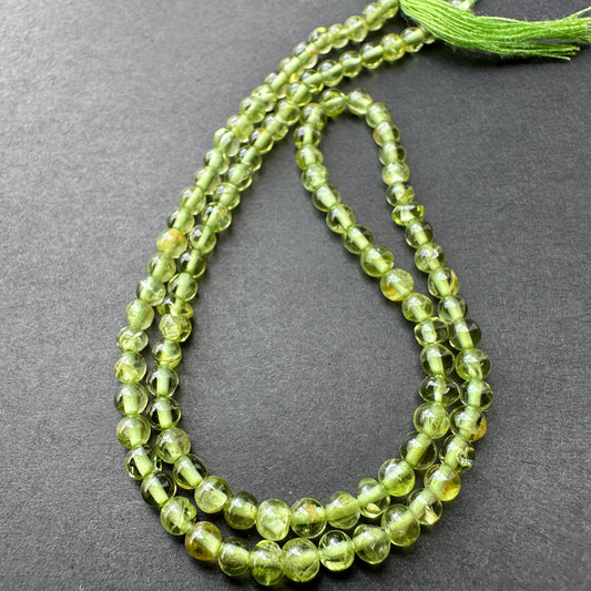 Close-up of Peridot stone beads showing smooth cut and natural gemstone shine.