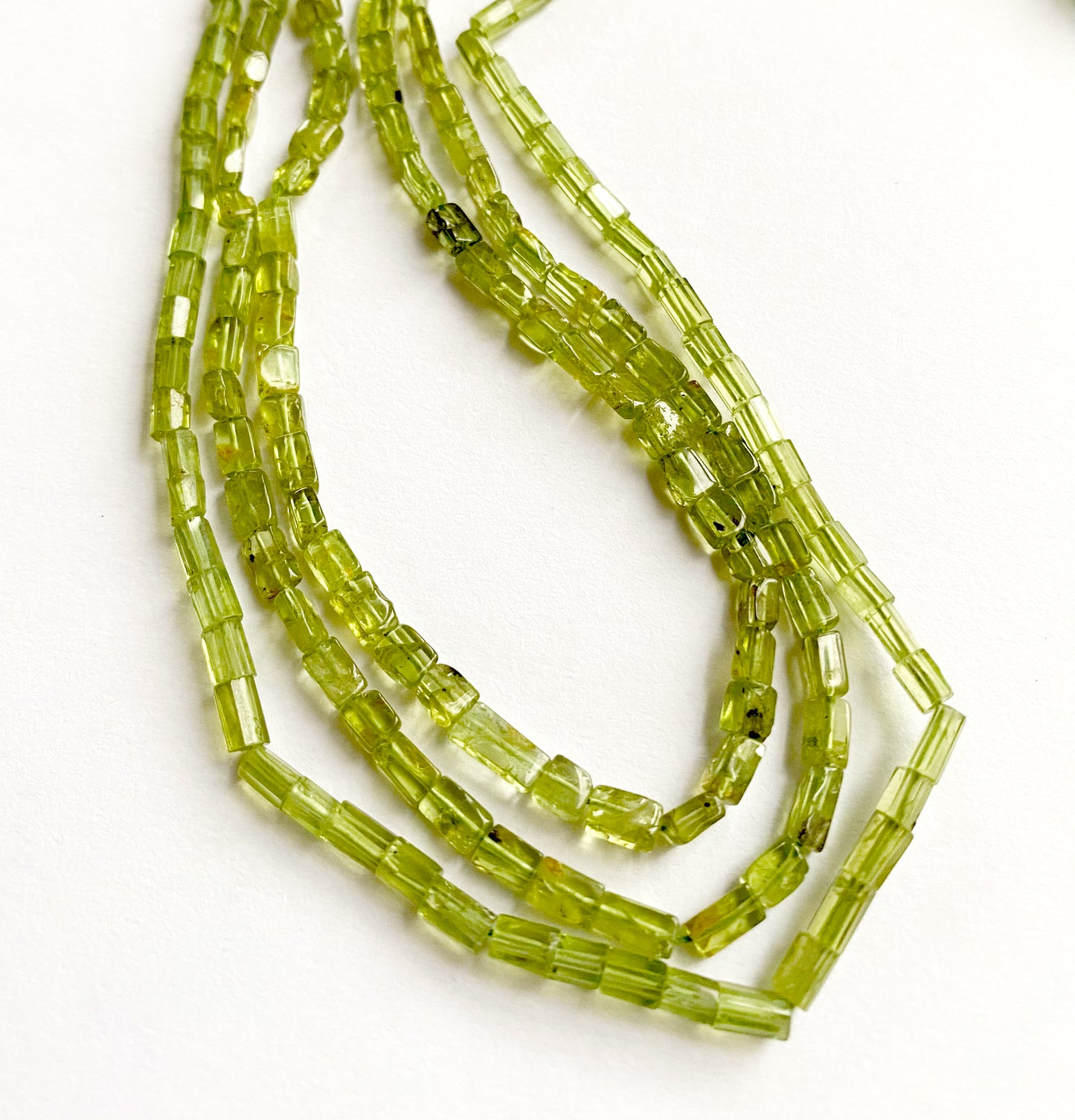 Natural green Peridot gems in tube form, reflecting light beautifully across a 34cm strand.