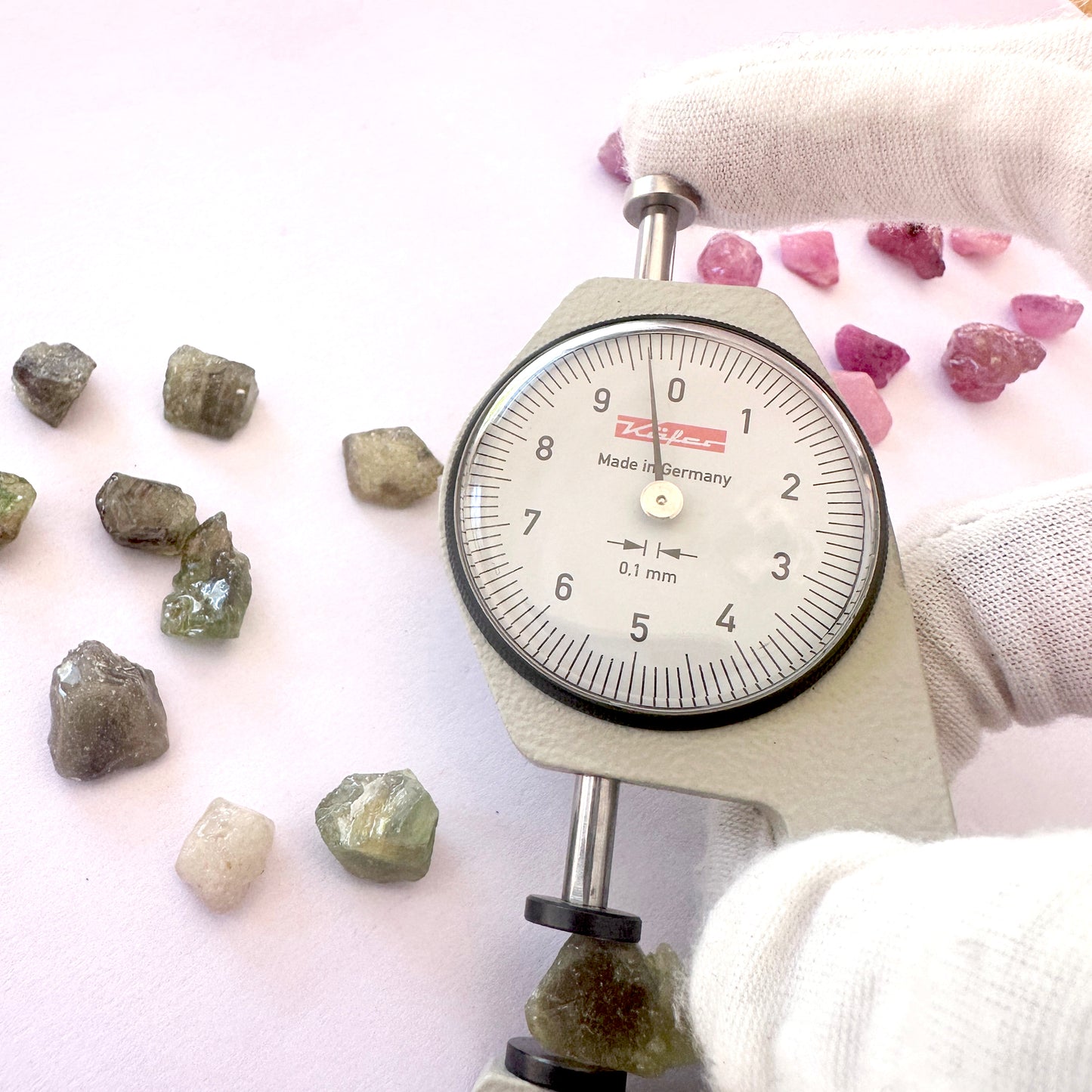 A dial gauge measures the sapphire rough cut 8–11mm gemstone.