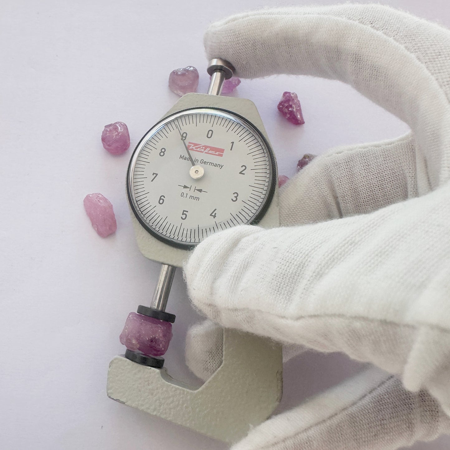 A dial gauge measures the sapphire rough cut 8–11mm gemstone.