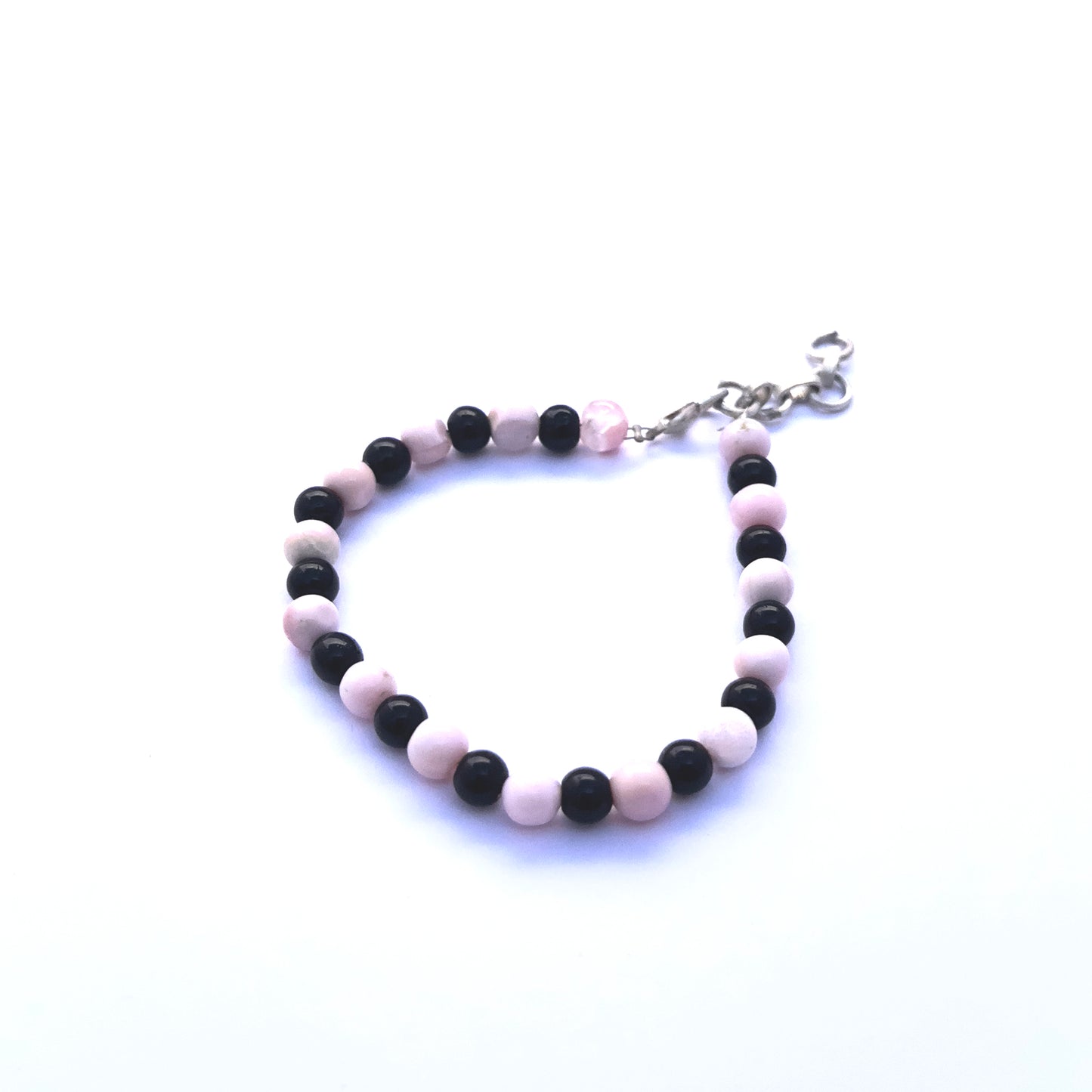 Natural gemstone beads in soft pink and bold black, styled into a sleek adjustable bracelet.