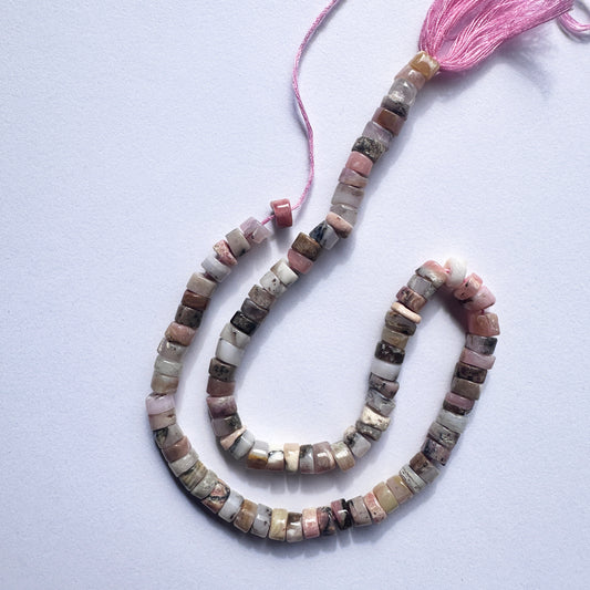 Stone beads with smooth Pink Opal arranged in a neat strand, ideal for handmade jewellery components.