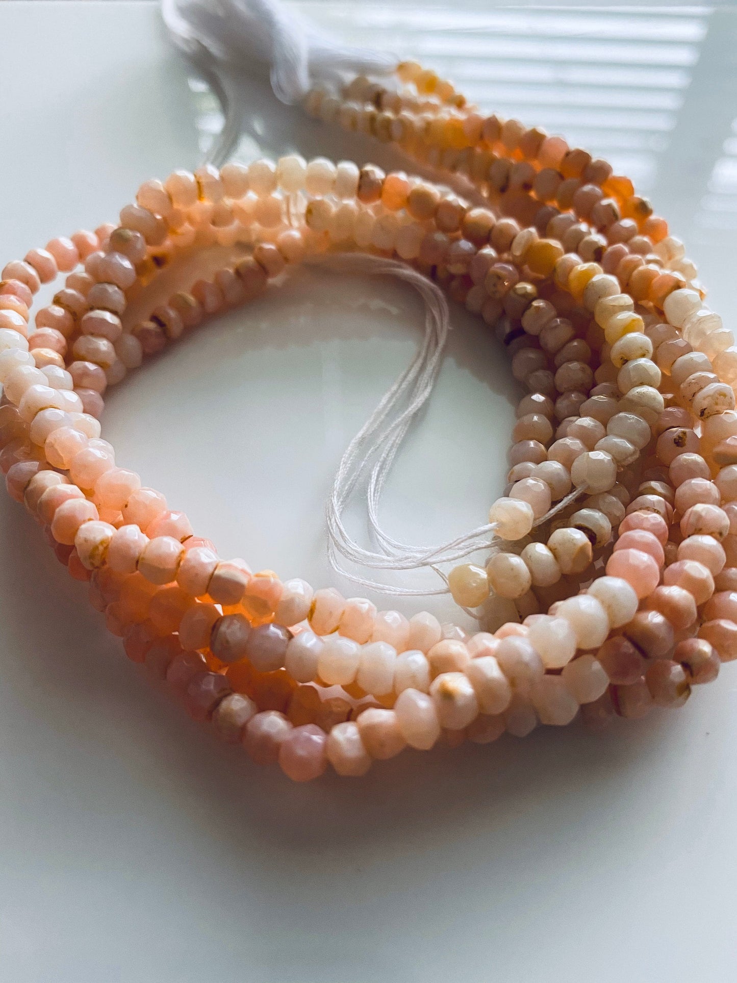 Close-up of 4.4mm to 4.7mm Pink Peruvian Opal beads, showcasing delicate faceted detailing.