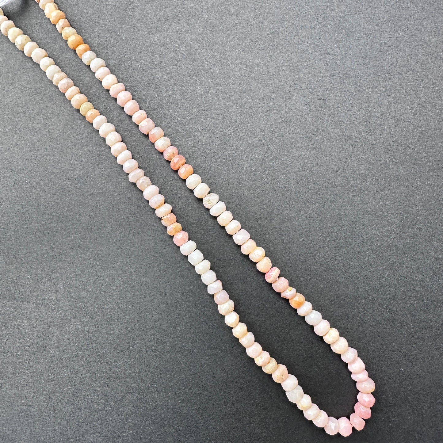Delicate strands of Pink Shaded Opal beads, showcasing their faceted design.