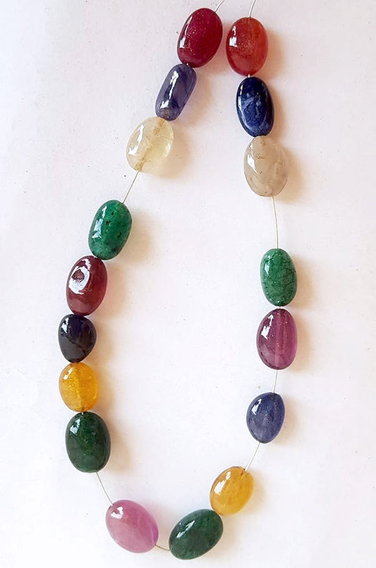 A vibrant multi-coloured strand featuring precious ruby, blue sapphire, yellow sapphire, and emerald beads on a white background.