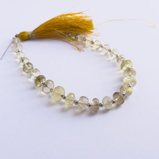 Stone beads in a strand of Prehnite, highlighting their polished facets and 6.5–9mm size.
