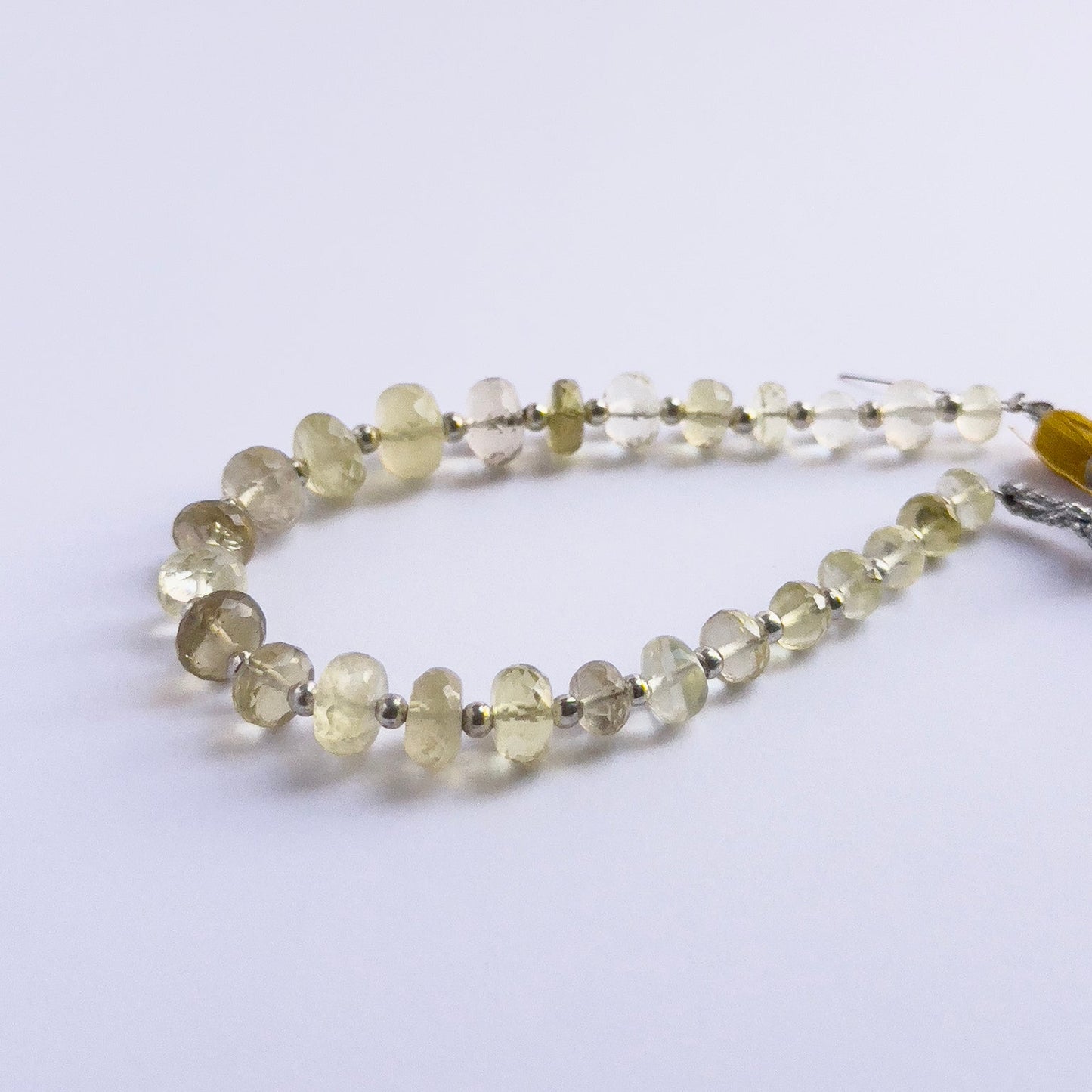 Handmade jewellery components featuring Prehnite faceted rondelle beads strung neatly together.