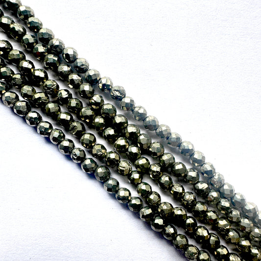 Close-up of pyrite gemstone beads arranged in a 32cm strand with faceted sparkle.