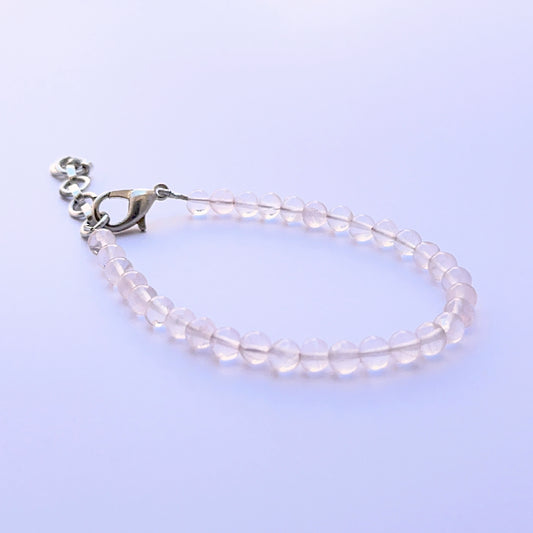 Close‑up of smooth round quartz beads arranged on a finished bracelet.