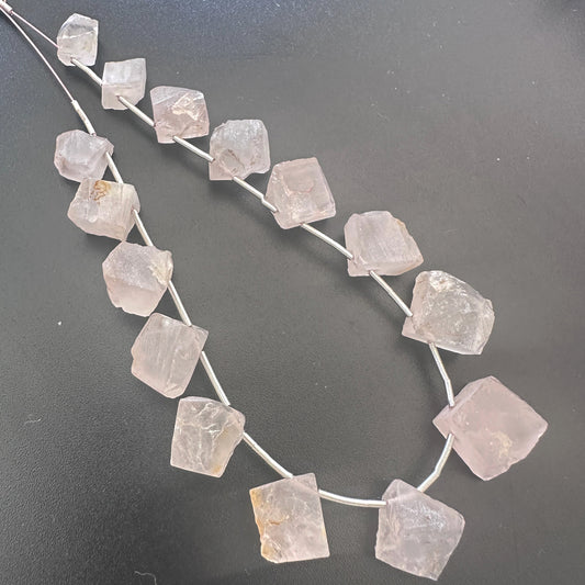 Close-up of side-drilled Quartz gemstones showing natural shimmer and organic cut.