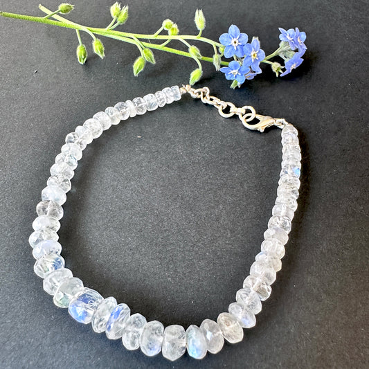Close-up of rainbow moonstone bracelet featuring faceted rondelle stone beads, luminous glow and polished shine.