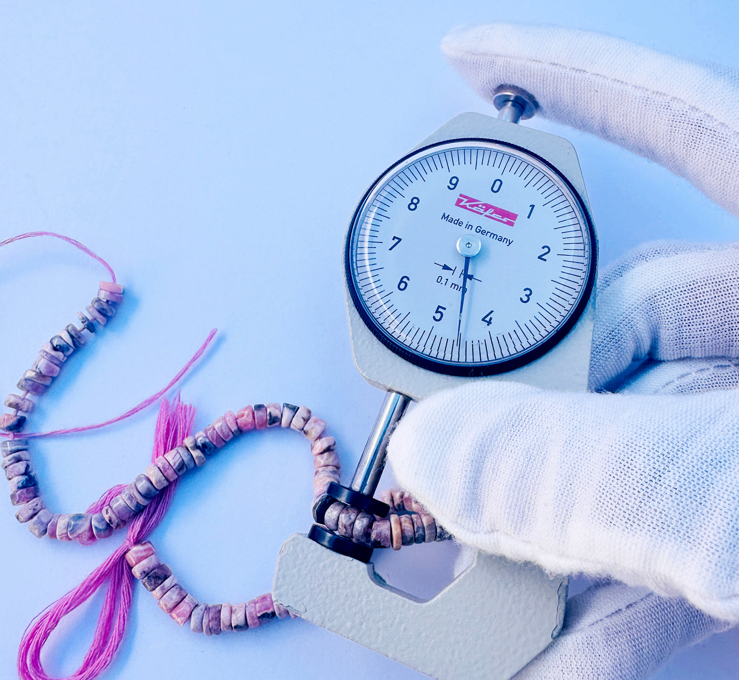 A dial gauge measures the Rhodonite smooth wheel 4.5mm gemstone.