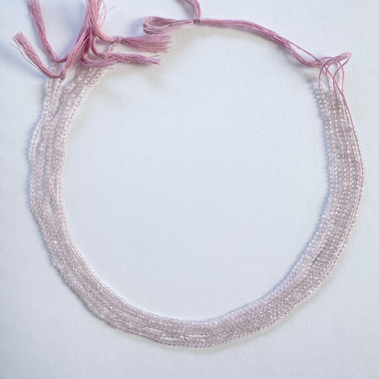 Close-up of Rose Quartz rondelle beads showing delicate faceting and gentle shine.
